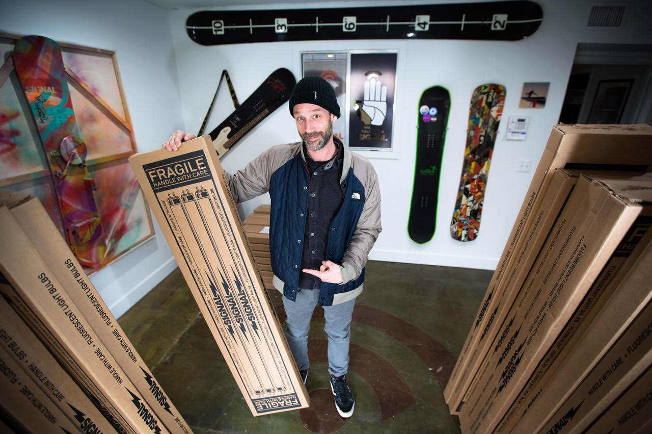 Signal Founder Dave Lee with a day's production. Signal screens its shipping boxes to resemble fragile fluorescent light tubes to get more careful freight handling. Photo courtesy Marc Wierenga.