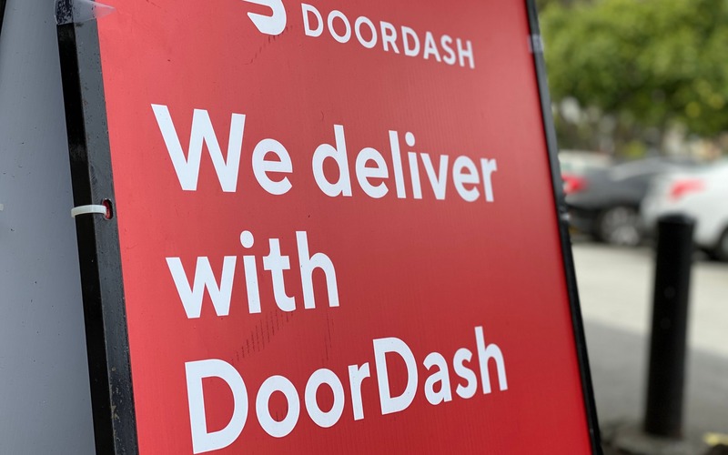 DoorDash sign reading "We deliver with DoorDash"